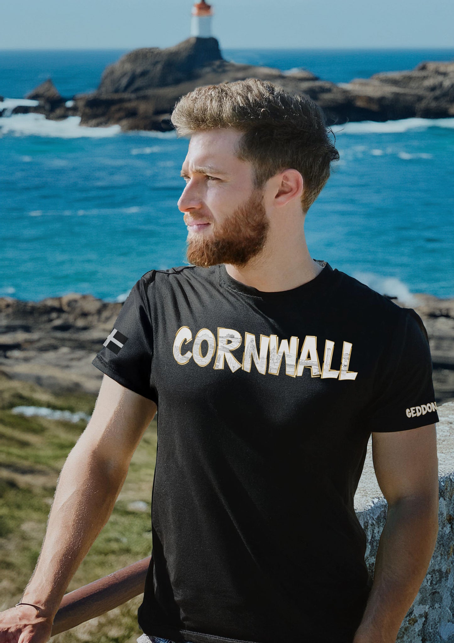 Model wearing black Cornwall T-shirt with line art letters featuring iconic Cornish landmarks – GeddonSurf design, unisex fit.