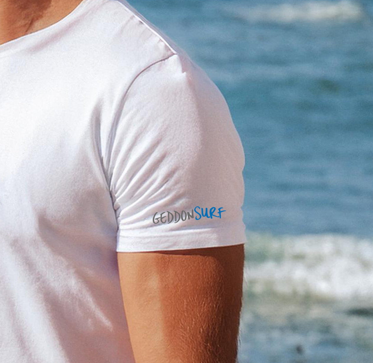 Close-up of the GeddonSurf branding on the sleeve of the Fistral Beach Line Art T-Shirt.