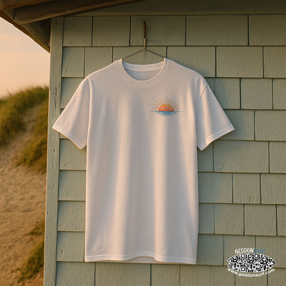 White t-shirt with a sun setting on a hanger against a wooden shed background.